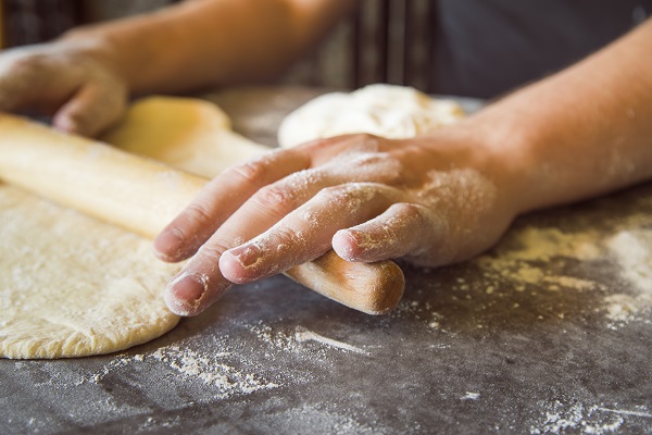 Professionista stende l'impasto per la pizza.