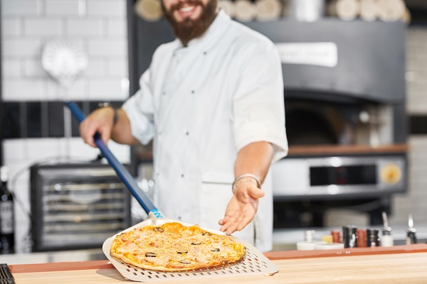 Pizzaiolo presenta la sua ultima pizza.